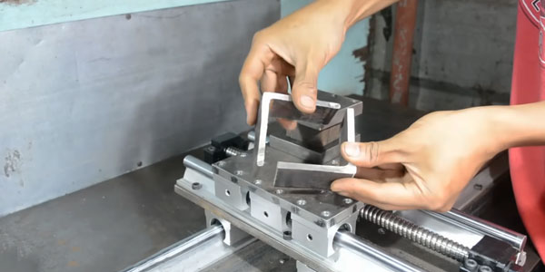 Proses setup benda kerja pada mesin milling custom menggunakan vise dan alat ukur