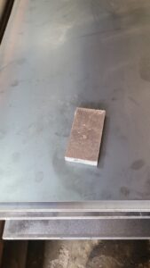 Potongan plat SS400 di atas lembaran besi